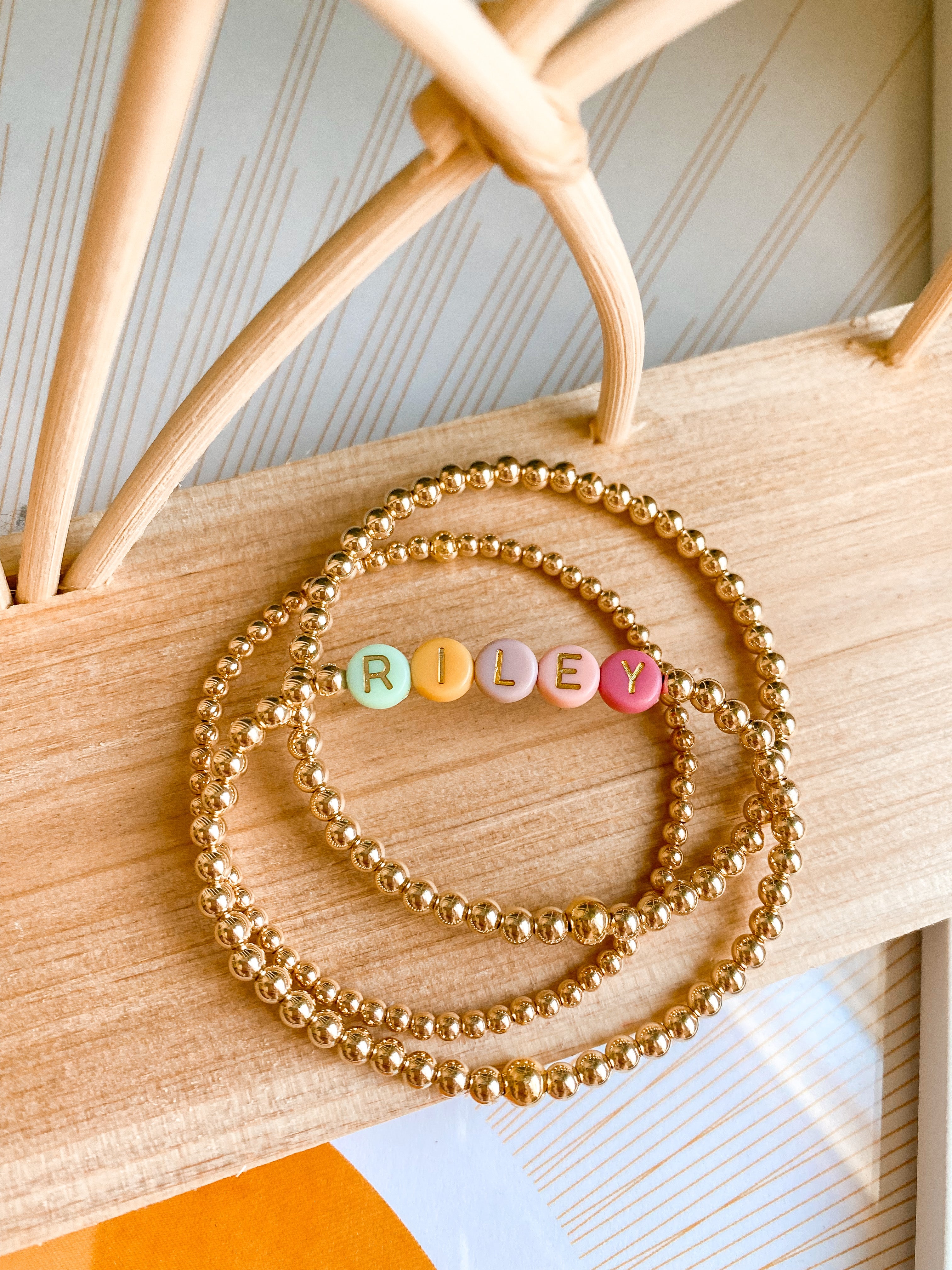 Fully customizable stack of 5 name/alphabet bracelets in gold